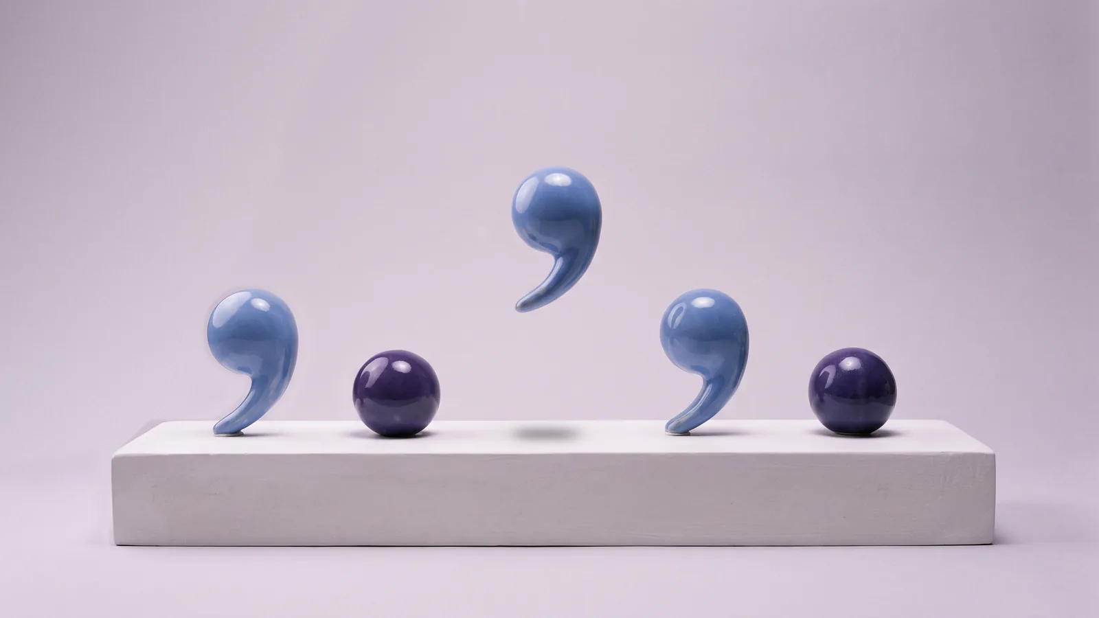 Blue and violet porcelain commas and periods stand in a row on a white podium, while one more comma settles into its place.
